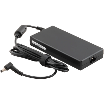 Schrägansicht des schwarzen XMG / SCHENKER 180 Watt Netzteils mit angeschlossenem Stromkabel, Ferritkern und gewinkeltem Ausgangsstecker.