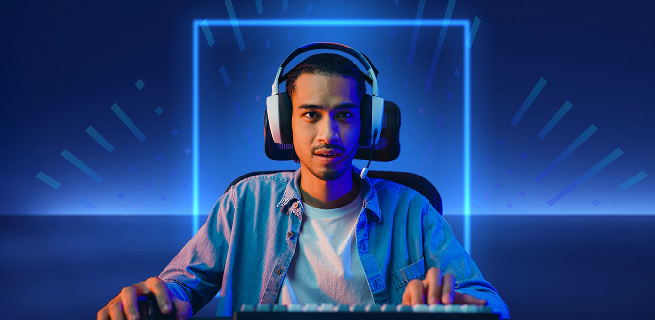 Gamer mit Headset sitzt vor Gaming-PC in einem Raum mit blauer Neon-Beleuchtung.