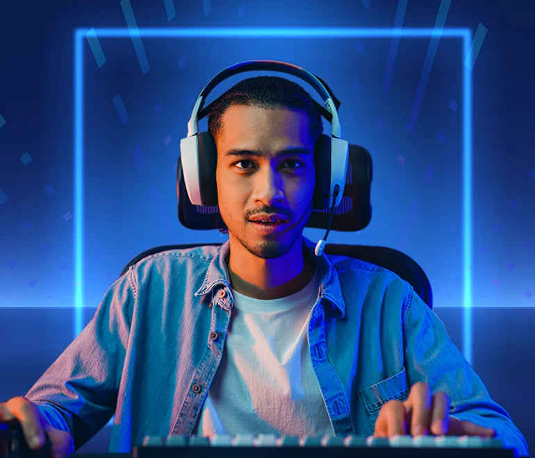 Gamer mit Gaming-Headset sitzt vor blau beleuchtetem Setup und tippt auf Tastatur.