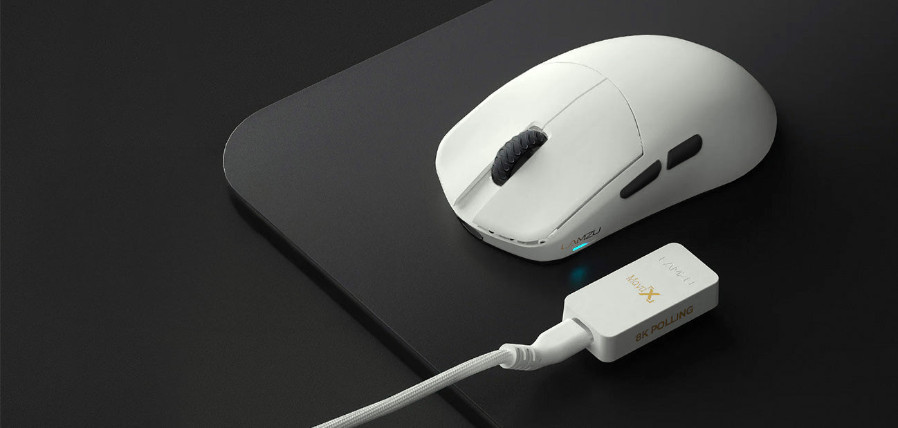 Weiße Lamzu Maya X Wireless Gaming-Maus mit 8K Polling-Rate Empfänger und Stoffmauspad auf dunklem Schreibtisch.