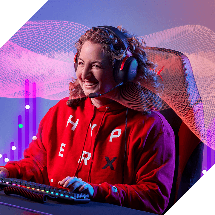 Lächelnte Gamerin mit HyperX Gaming-Headset am PC mit RGB-Tastatur