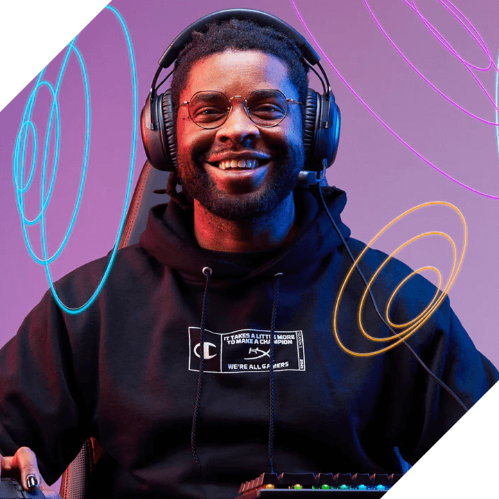 Lächelnder Gamer mit Gaming-Headset und Brille sitzt vor RGB-Peripherie in einem beleuchteten Raum.