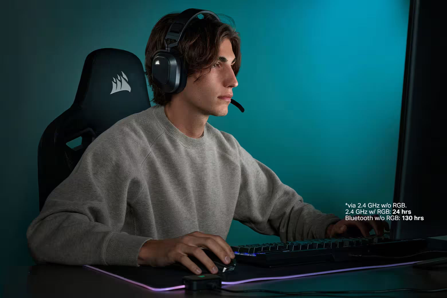 Gamer mit Corsair Headset sitzt vor Gaming-Setup mit RGB-Tastatur und Maus