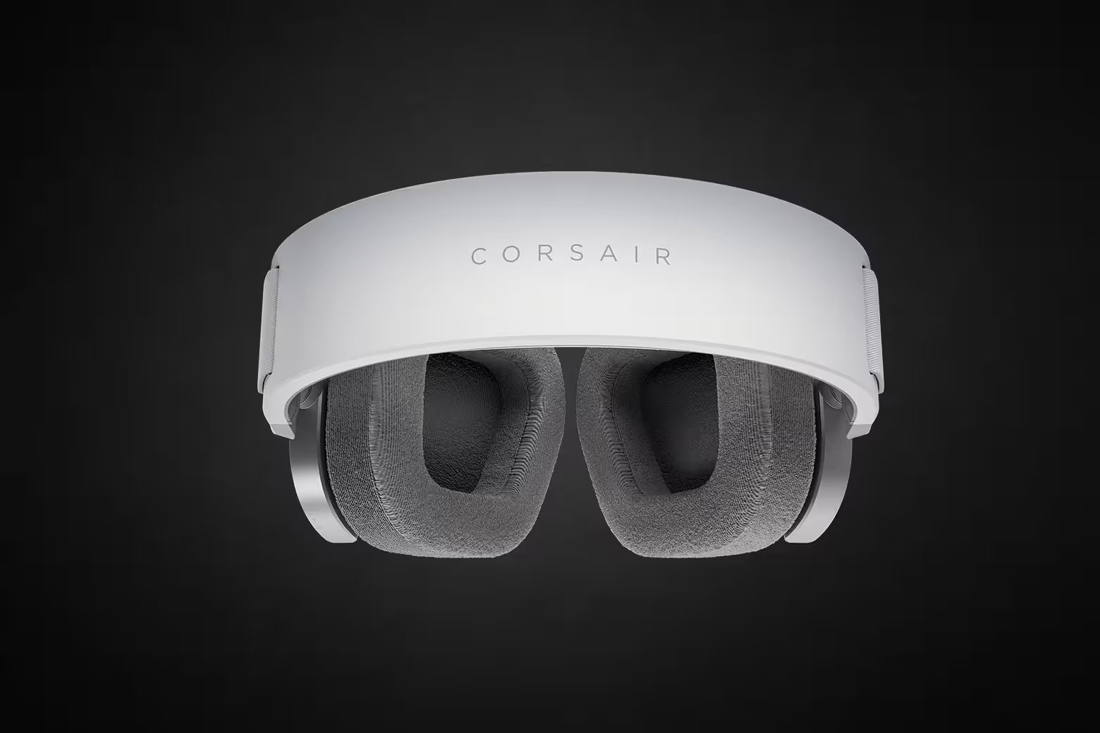 Weiße Corsair Gaming-Headset-Ohrmuscheln mit grauem Stoffbezug und Kopfbügel vor dunklem Hintergrund.