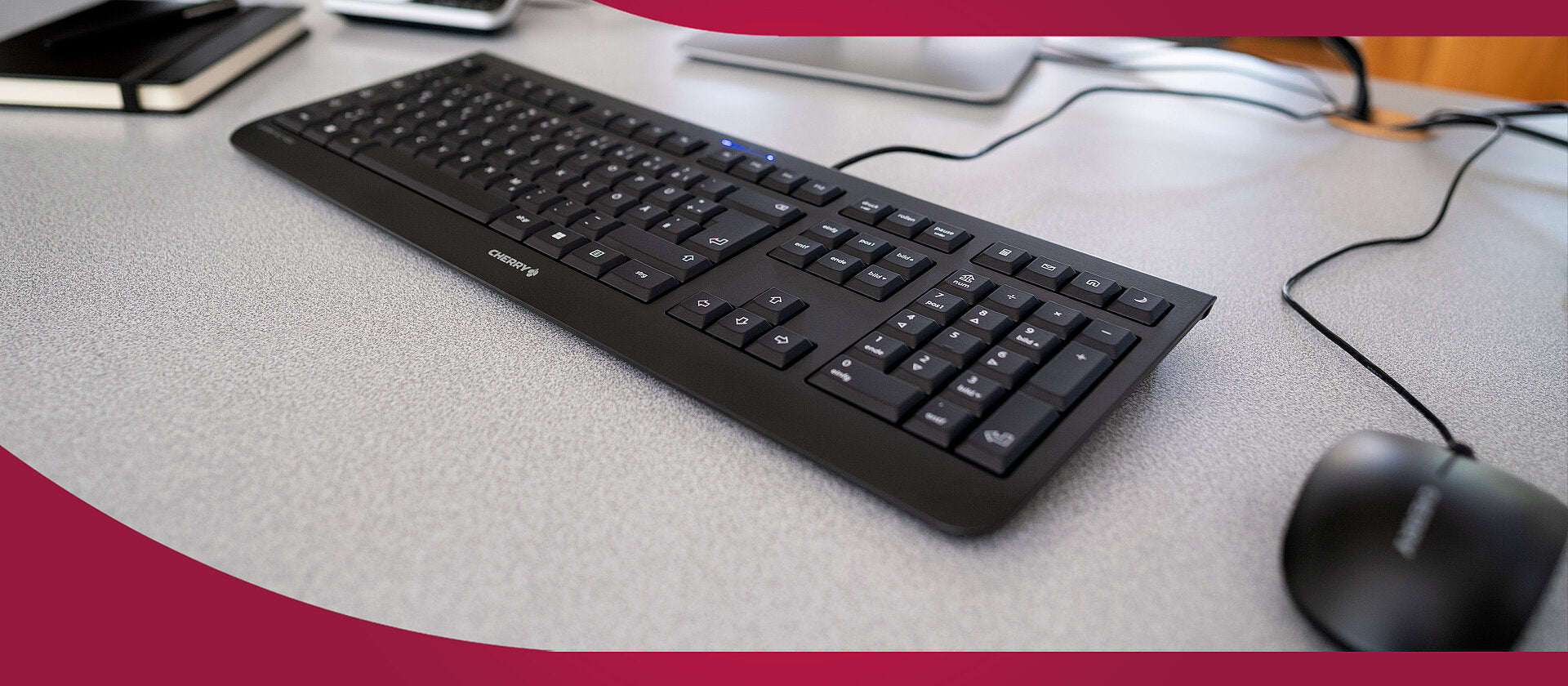 Schwarze Cherry Tastatur und passende Maus auf hellem Schreibtisch