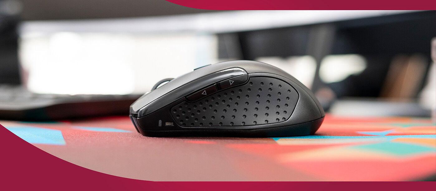 Seitenansicht einer ergonomischen Gaming-Maus mit Daumentasten auf einem bunten Mauspad