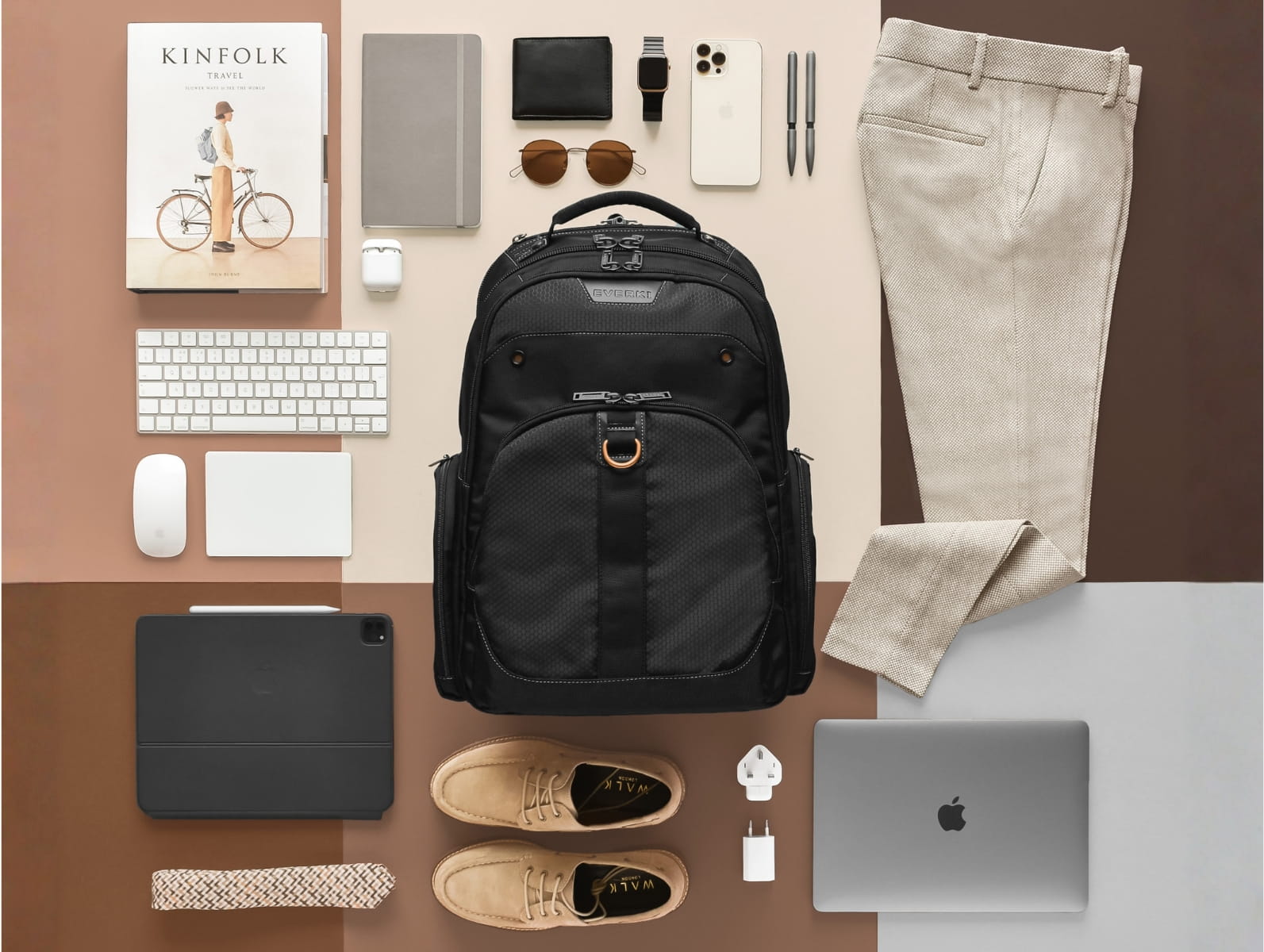 Schwarzer Business-Rucksack im Zentrum, umgeben von Laptop, Tablet, Tastatur, Gadgets und Business-Kleidung.
