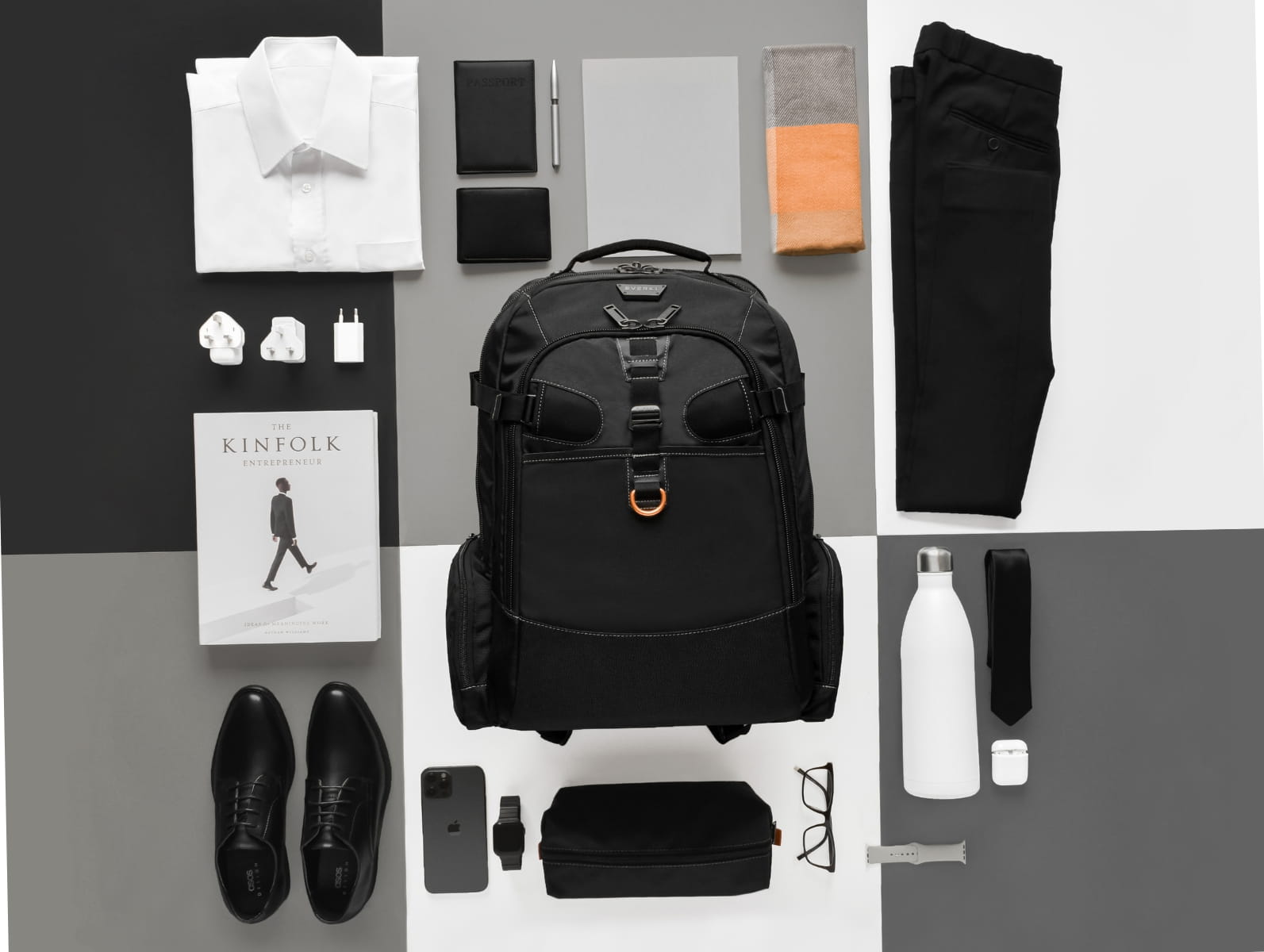 Schwarzer Everki Laptop-Rucksack umgeben von Business-Accessoires, Hemd und Gadgets im Flatlay-Design