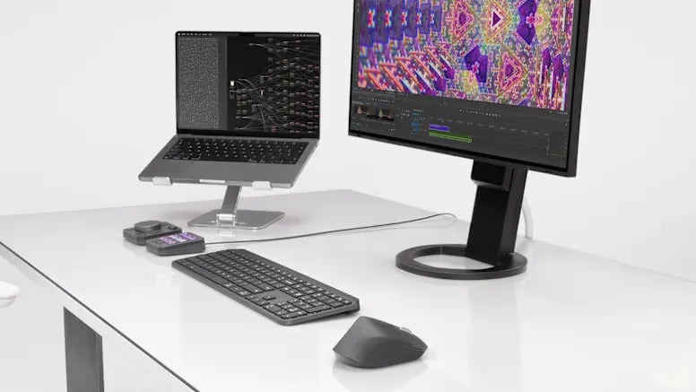 Ergonomischer High-End Arbeitsplatz mit Laptop auf Ständer, externem Monitor, Tastatur, ergonomischer Maus und Eingabegeräten.