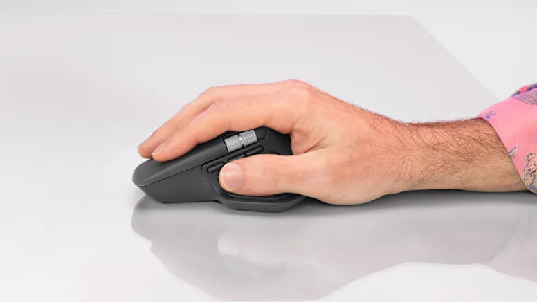 Hand bedient eine ergonomische High-End-Maus mit Daumenrad auf einem hellen Schreibtisch.