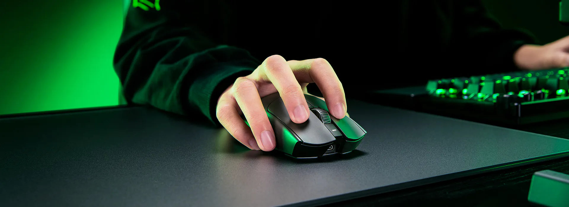 Hand bedient eine ergonomische Gaming-Maus mit RGB-Beleuchtung auf einem Mauspad