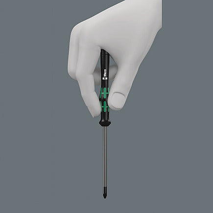 Hand hält einen ergonomischen Wera Feinmechaniker-Schraubendreher mit grün-schwarzem Griff vor grauem Hintergrund