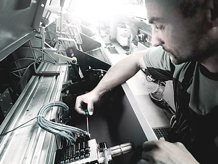 Techniker montiert und verschraubt präzise IT-Hardware in der internen Fertigung.