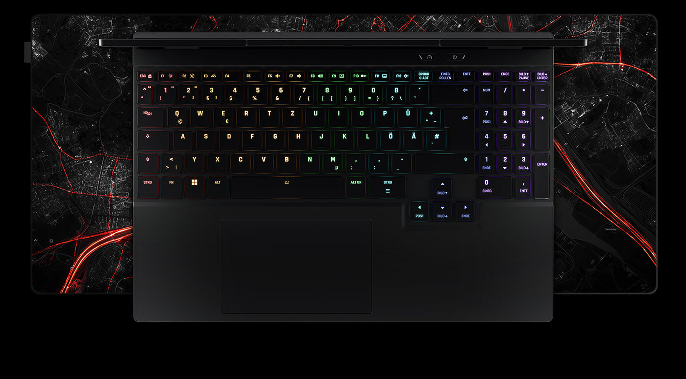 Draufsicht auf die beleuchtete Tastatur und das Touchpad eines High-End Gaming-Laptops auf einem roten Stadtkarten-Mauspad.