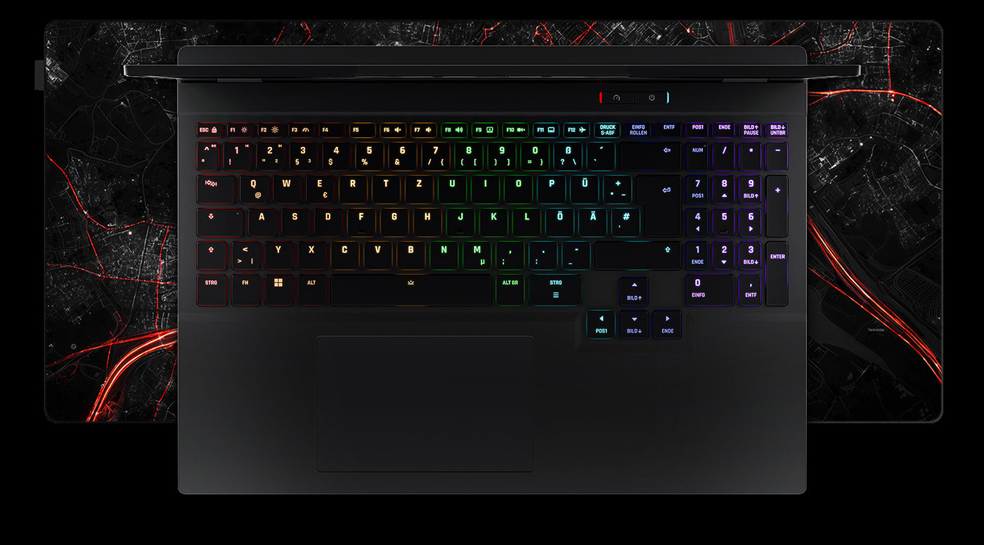 Draufsicht auf die beleuchtete RGB-Tastatur eines High-End Gaming-Laptops auf einem großen Mauspad.