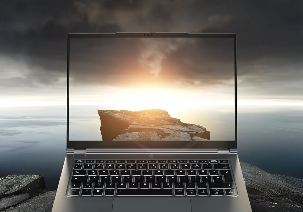 High-End Laptop mit beleuchteter Tastatur und hochauflösendem Display, das eine dramatische Felsenlandschaft zeigt.