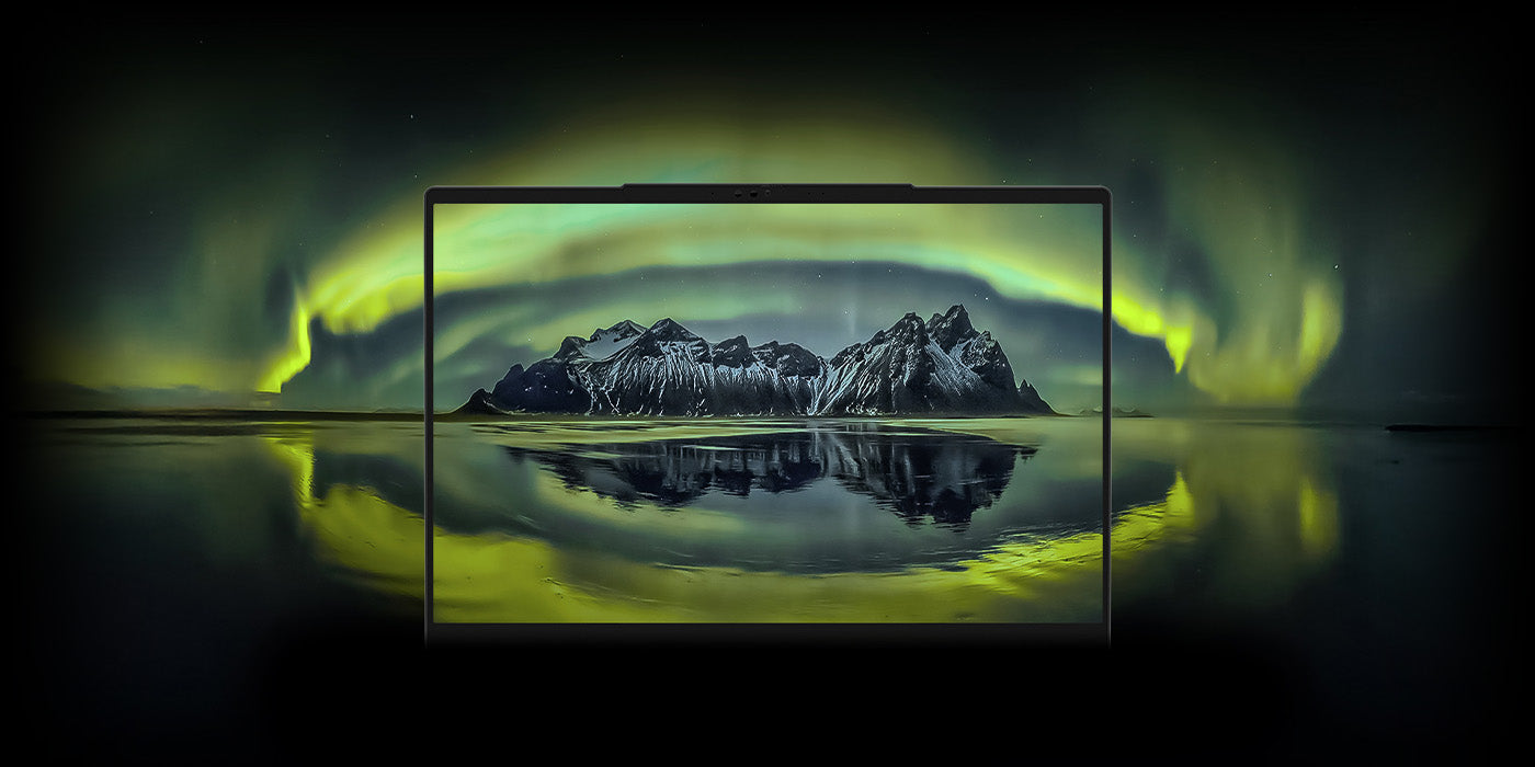 High-End Laptop zeigt brillantes Display mit Berglandschaft und Polarlichtern vor dunklem Hintergrund.