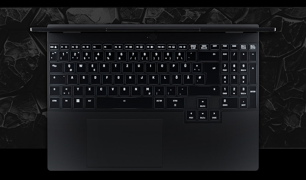 Draufsicht auf die beleuchtete Tastatur und das Touchpad eines schwarzen High-End Gaming-Laptops