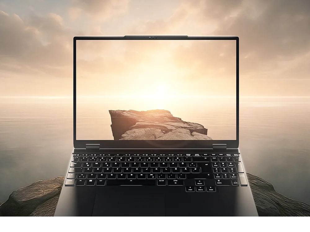 Hochwertiger Laptop mit beleuchteter Tastatur auf einer Klippe, während Bildschirm und Hintergrund nahtlos ineinander übergehen.