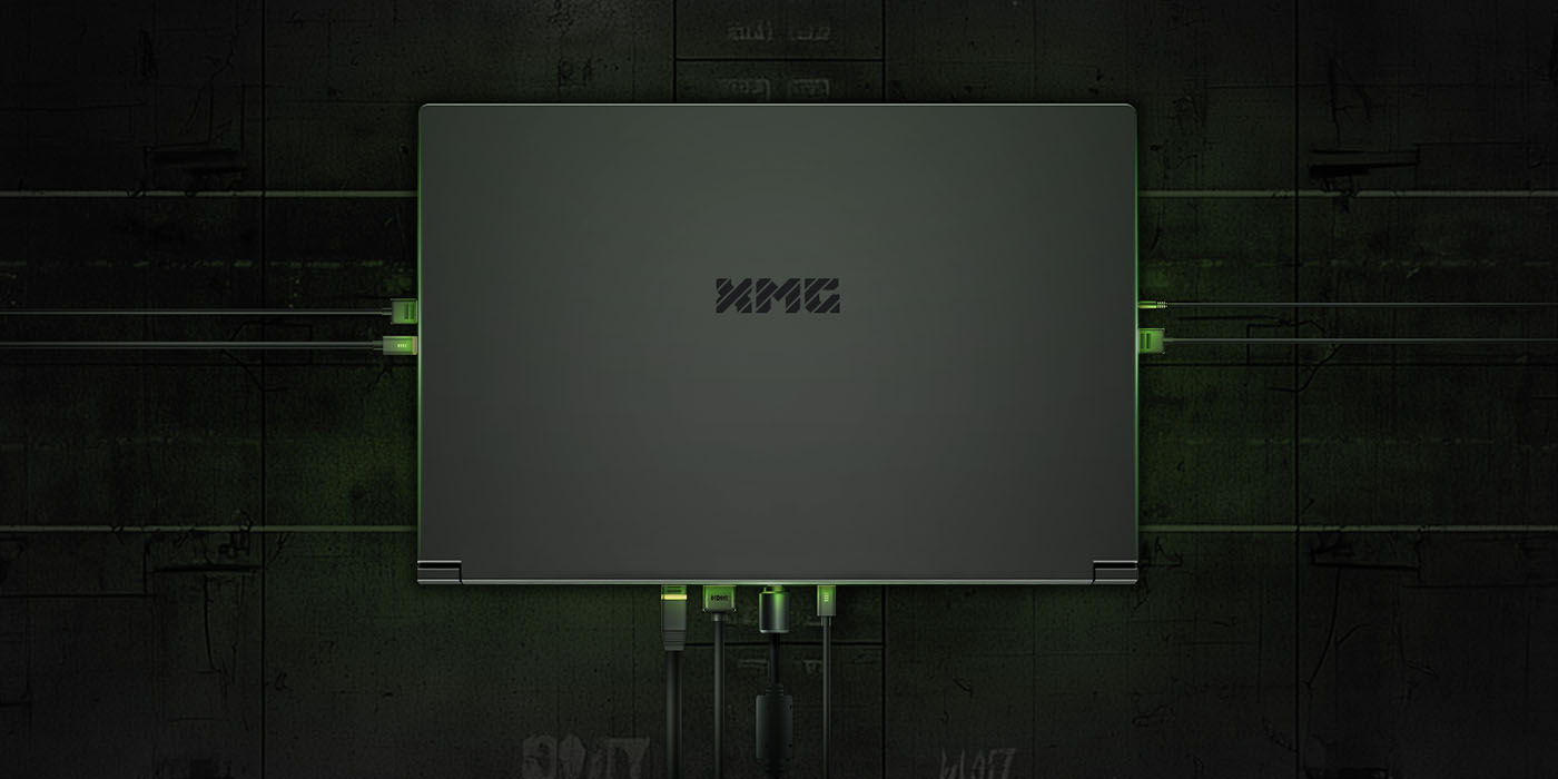 XMG Gaming-Laptop von oben mit angeschlossenen Kabeln und Anschlüssen an allen Seiten vor dunklem Hintergrund.
