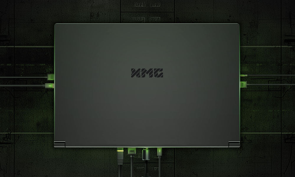Draufsicht auf den geschlossenen XMG Gaming-Laptop mit zahlreichen angeschlossenen Kabeln und grünem Unterbodenlicht.