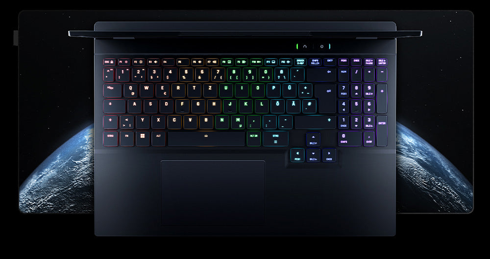 Draufsicht auf die beleuchtete RGB-Tastatur und das Touchpad eines High-End Gaming-Laptops auf einer Schreibtischunterlage