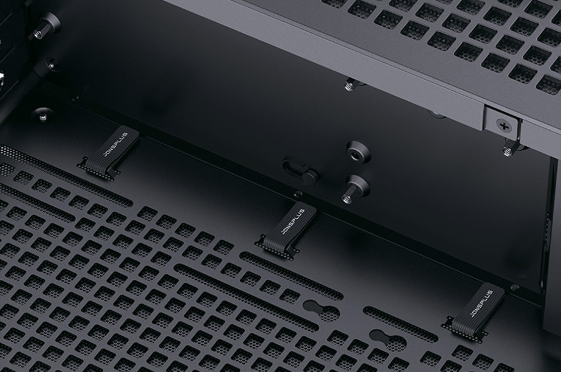 Nahaufnahme des schwarzen PC-Gehäuseinnenraums mit integrierten Kabelbindern von Jonsplus und Lüftungsschlitzen.