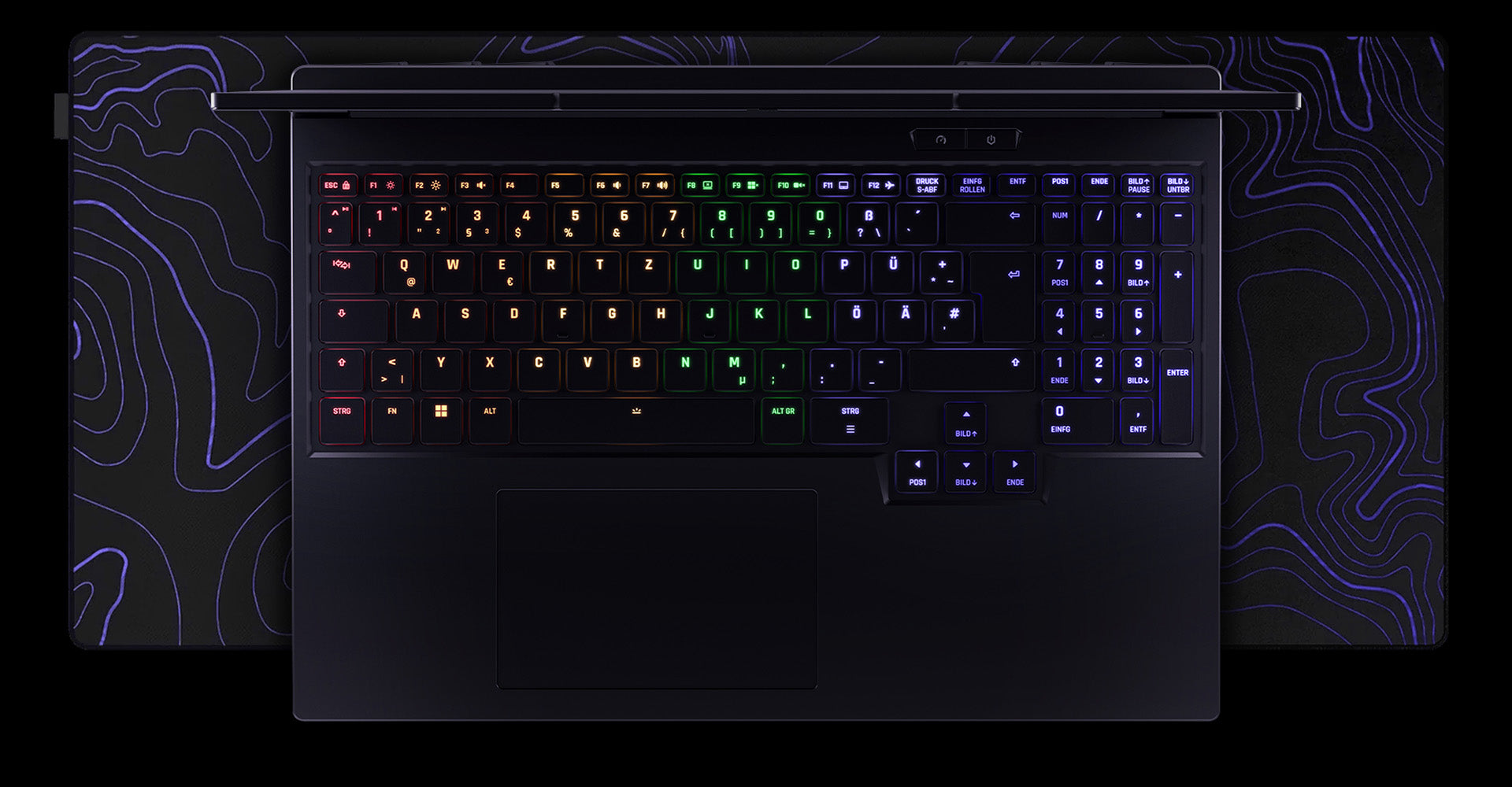 Draufsicht auf die RGB-beleuchtete Tastatur und das Touchpad eines High-End Gaming-Laptops auf einem Mauspad.