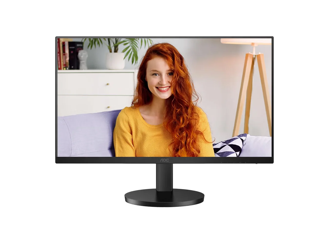 AOC Monitor zeigt lächelnde junge Frau mit roten Haaren vor heller Wohnzimmerkulisse.