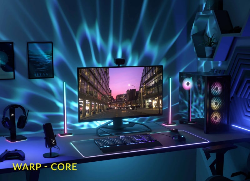 Modernes Gaming-Setup mit beleuchtetem PC, Monitor, RGB-Tastatur und blauer Wandprojektion
