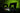 Zwei XMG Gaming-Laptops vor grünem Hintergrund mit XMG-Logo auf dem Display und stimmungsvoller RGB-Beleuchtung