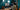 Content Creator streamt an High-End Gaming PC mit Studioweg, Monitor, Kamera und Studiobeleuchtung im teal-farbenen Zimmer.