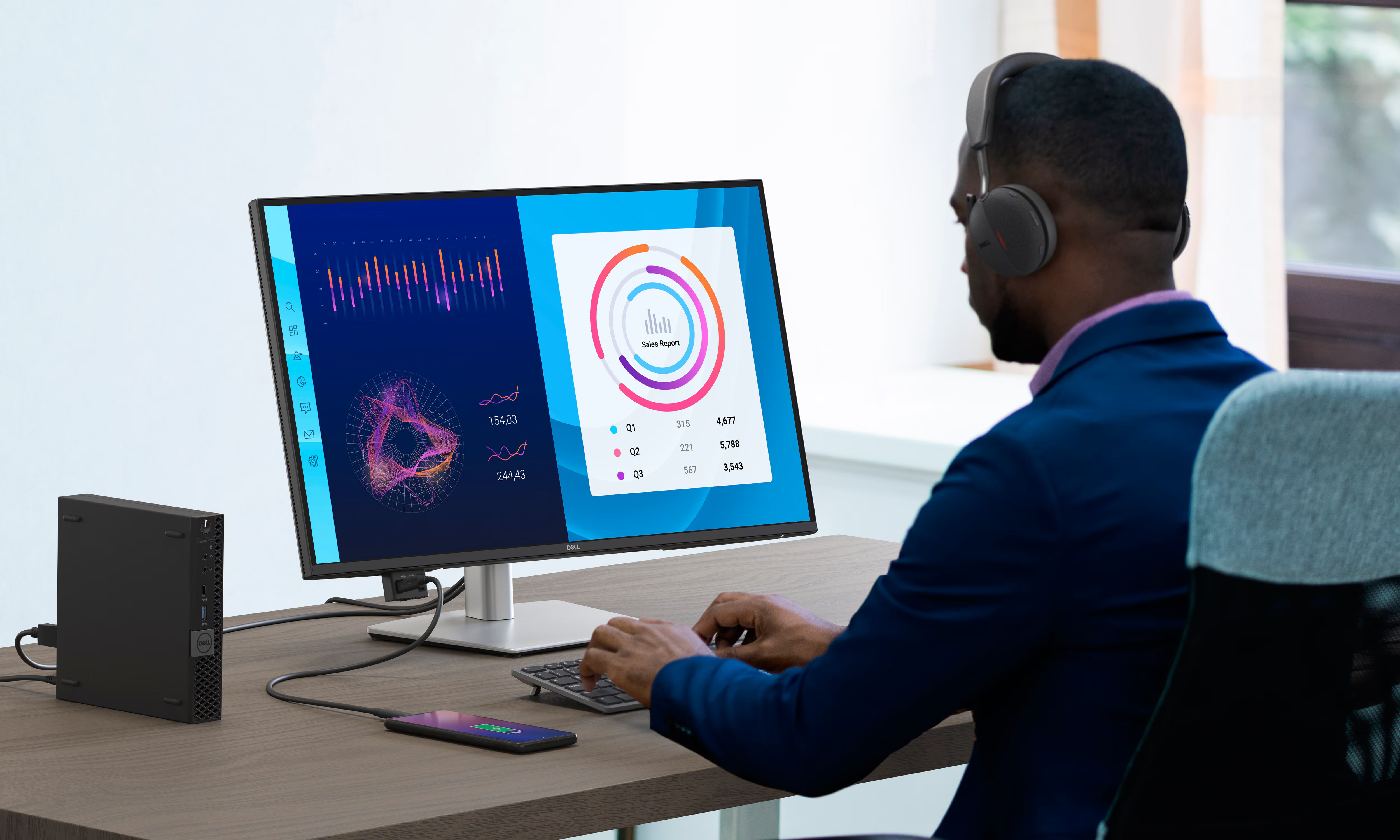 Ein Geschäftsmann arbeitet an einem modernen Dell Monitor mit Business-PC, Tastatur und Headset am Schreibtisch.