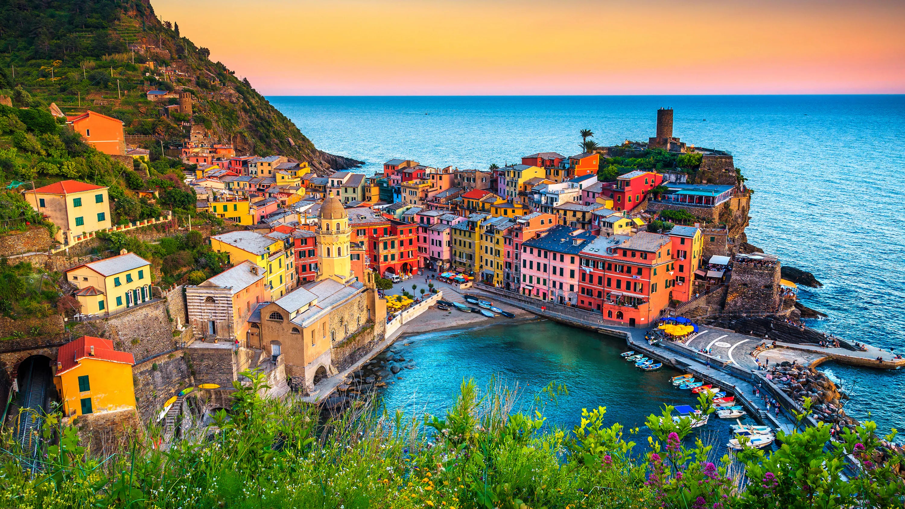 Blick auf das malerische Küstendorf Vernazza in den Cinque Terre bei Sonnenuntergang mit bunten Häusern und Meer.