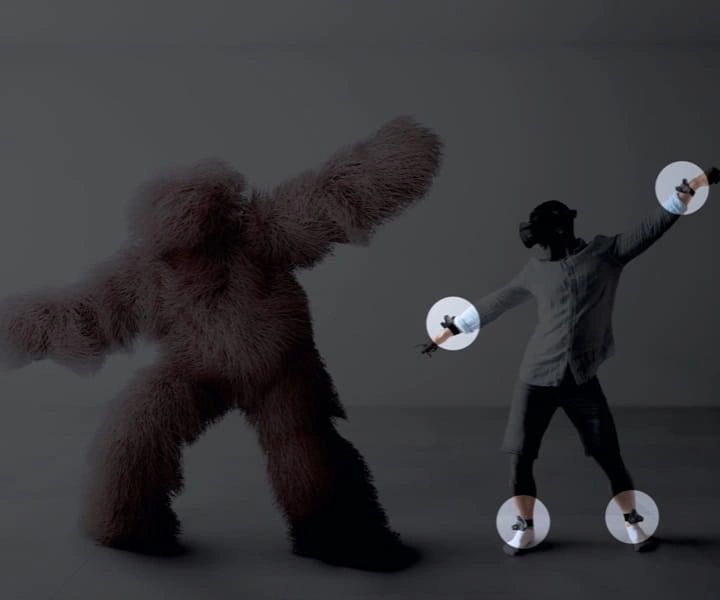 Person mit VR-Headset und Tracking-Sensoren interagiert virtuell mit einem zotteligen Monster.