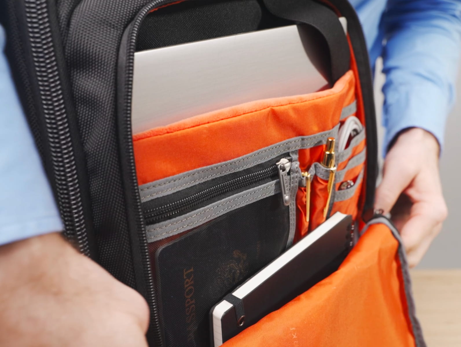 Offener Business-Laptop-Rucksack mit orangem Innenfach, integriertem Laptop-Sicherheitsfach und praktischen Organizer-Taschen.