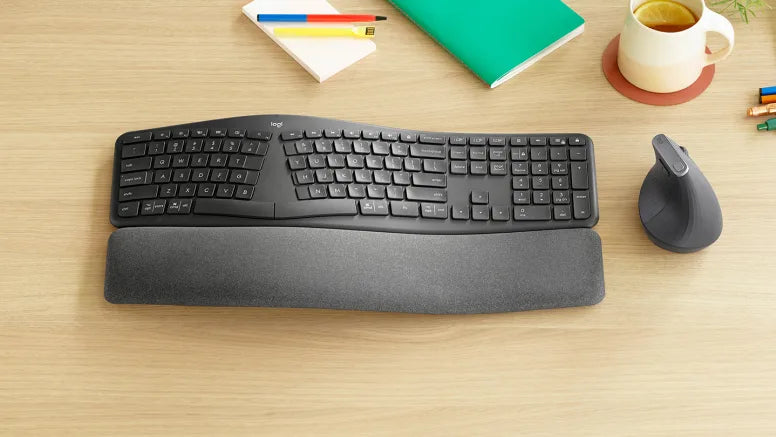 Ergonomische Logitech Wireless-Tastatur mit Handballenauflage und vertikaler Maus auf einem Holzschreibtisch.