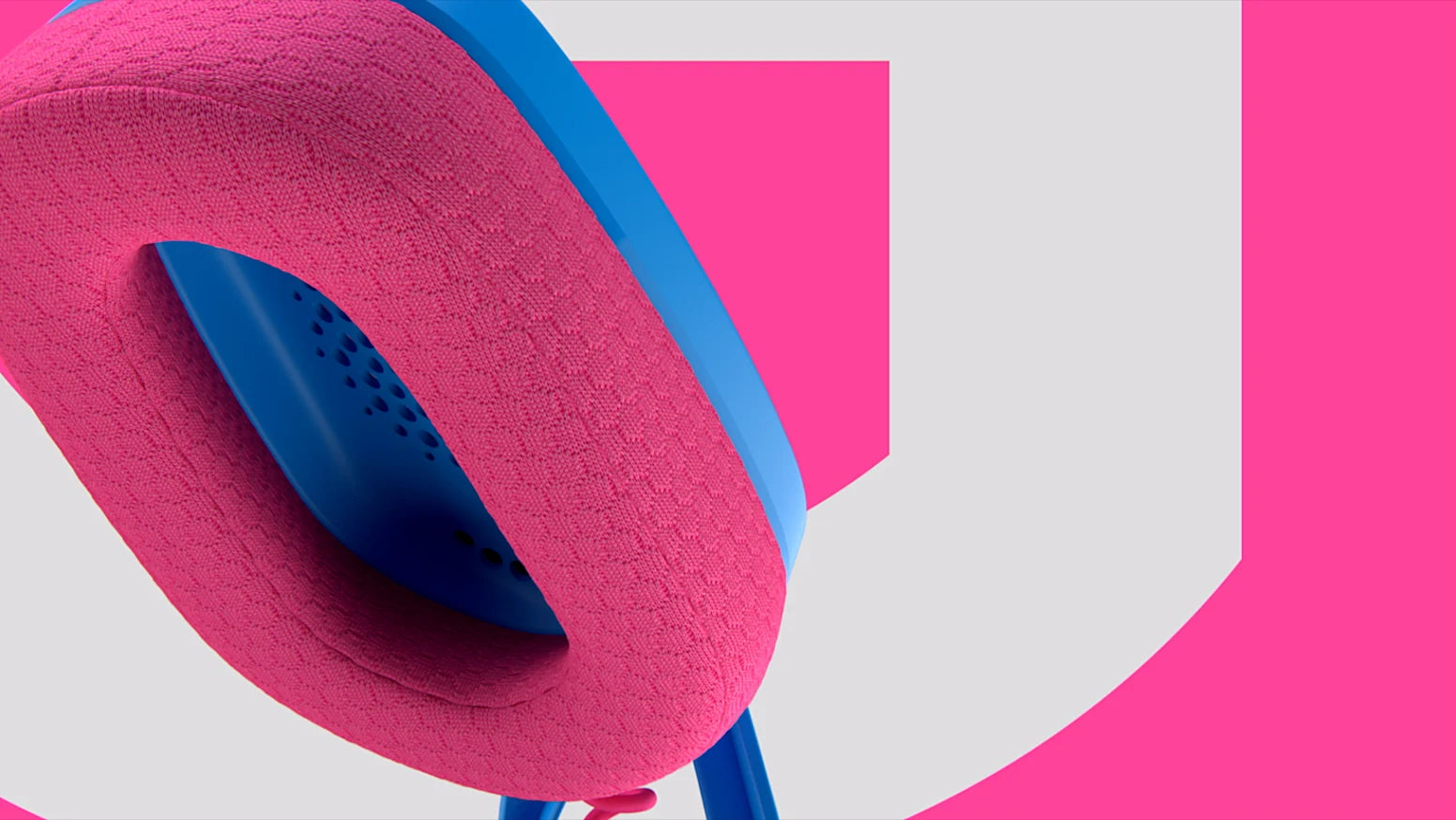 Nahaufnahme des pinken Stoff-Ohrpolsters und blauen Gehäuses eines Gaming-Headsets vor pink-weißem Hintergrund