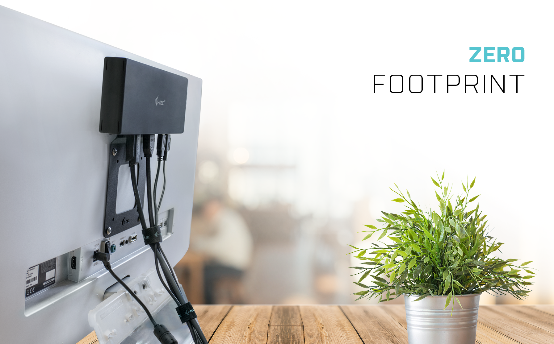 i-tec Docking Station an der Monitorrückseite montiert mit Kabelmanagement aufgeräumtem Holztisch und Pflanze