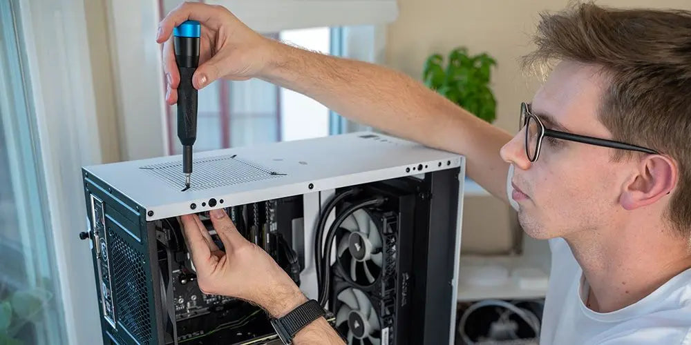 Junge baut Gaming PC zusammen und verschraubt die Hardware mit einem Schraubenzieher