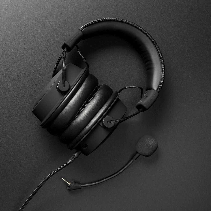 Schwarzes Gaming-Headset mit dickem Kopfbügel, Ohrmuscheln und abnehmbarem Mikrofon auf dunklem Untergrund.