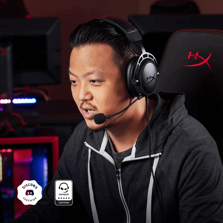 Gamer mit HyperX Gaming-Headset und Mikrofon an einem beleuchteten PC-Arbeitsplatz.
