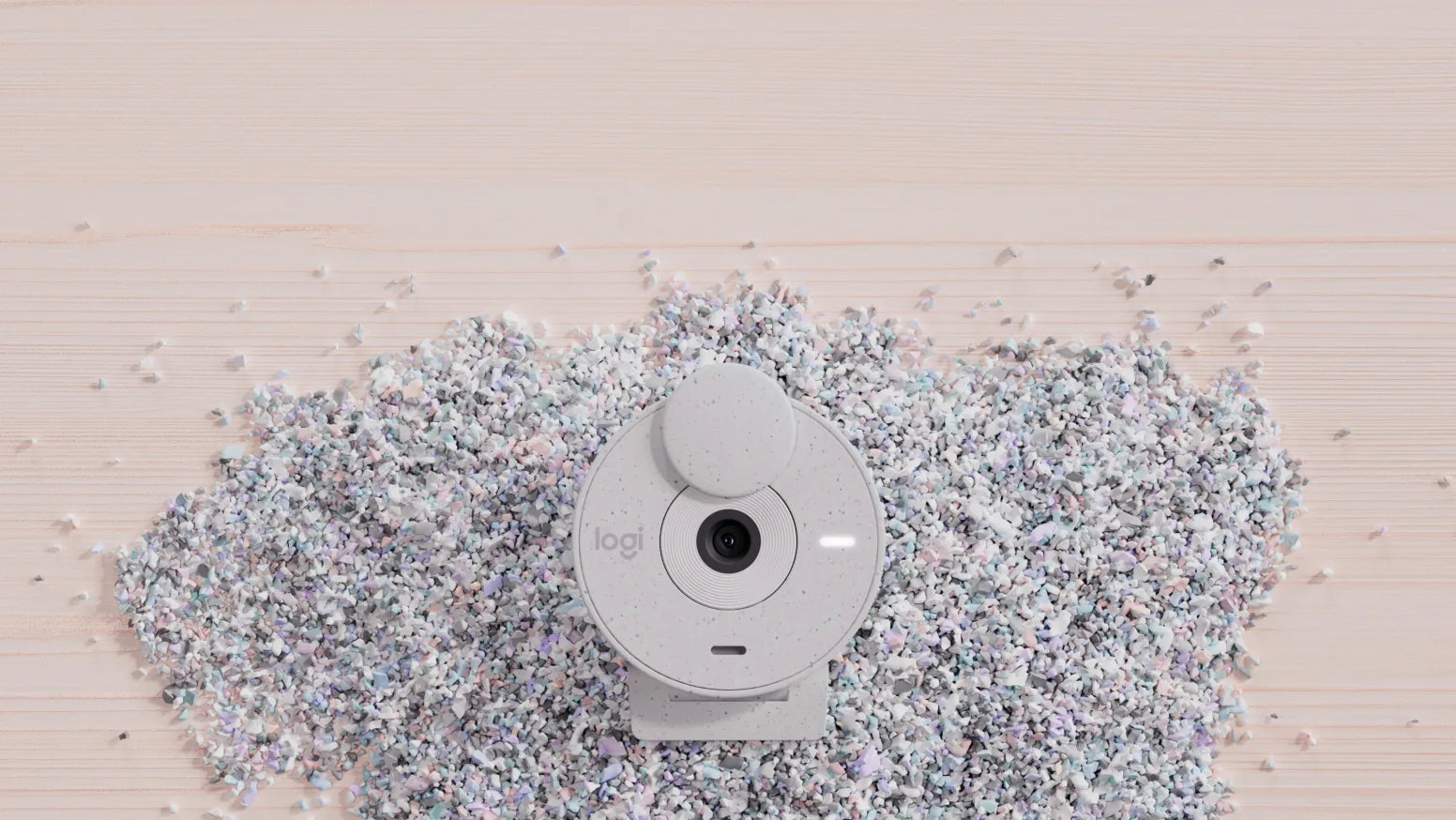 Weisse Logitech Webcam liegt auf einem Haufen recycelter Schaumstoff-Schnipsel