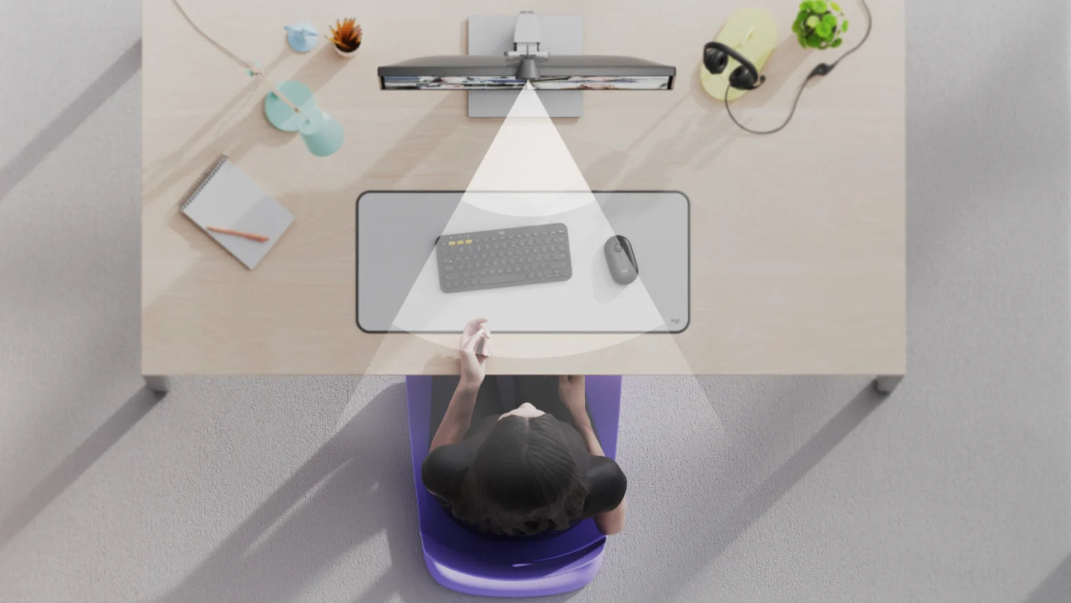 Draufsicht auf einen aufgeräumten Schreibtisch mit Monitor, Tastatur, Maus und einer beleuchteten Arbeitsfläche.