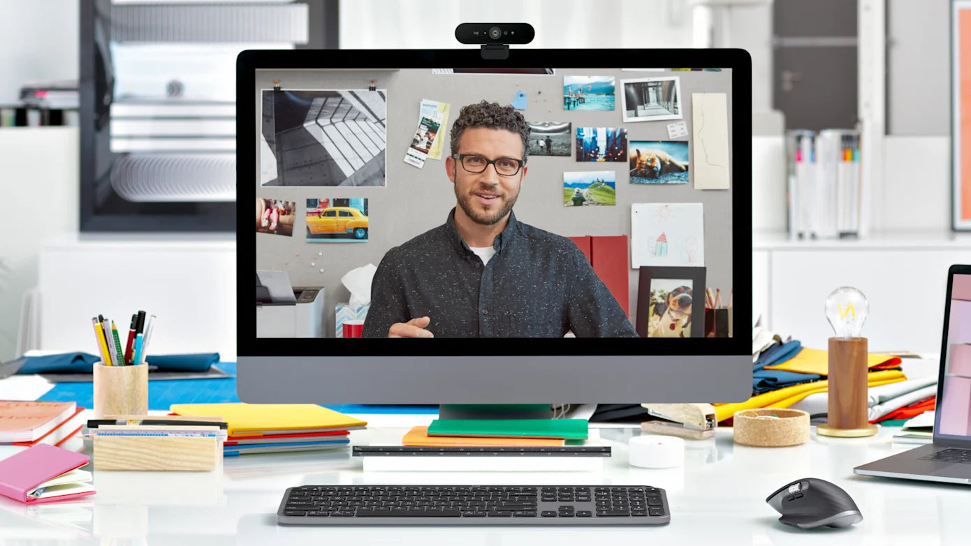 Videokonferenz auf einem Desktop-Monitor mit Webcam im modernen Homeoffice-Arbeitsplatz mit Tastatur und Maus