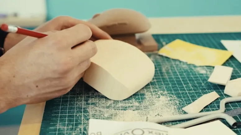 Handgefertigter Prototyp einer Gaming-Maus aus Schaumstoff bei der präzisen Bearbeitung auf einer Schneidematte.