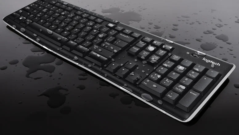 Schwarze Logitech-Tastatur mit Wassertropfen auf den Tasten und der glänzenden Oberfläche.