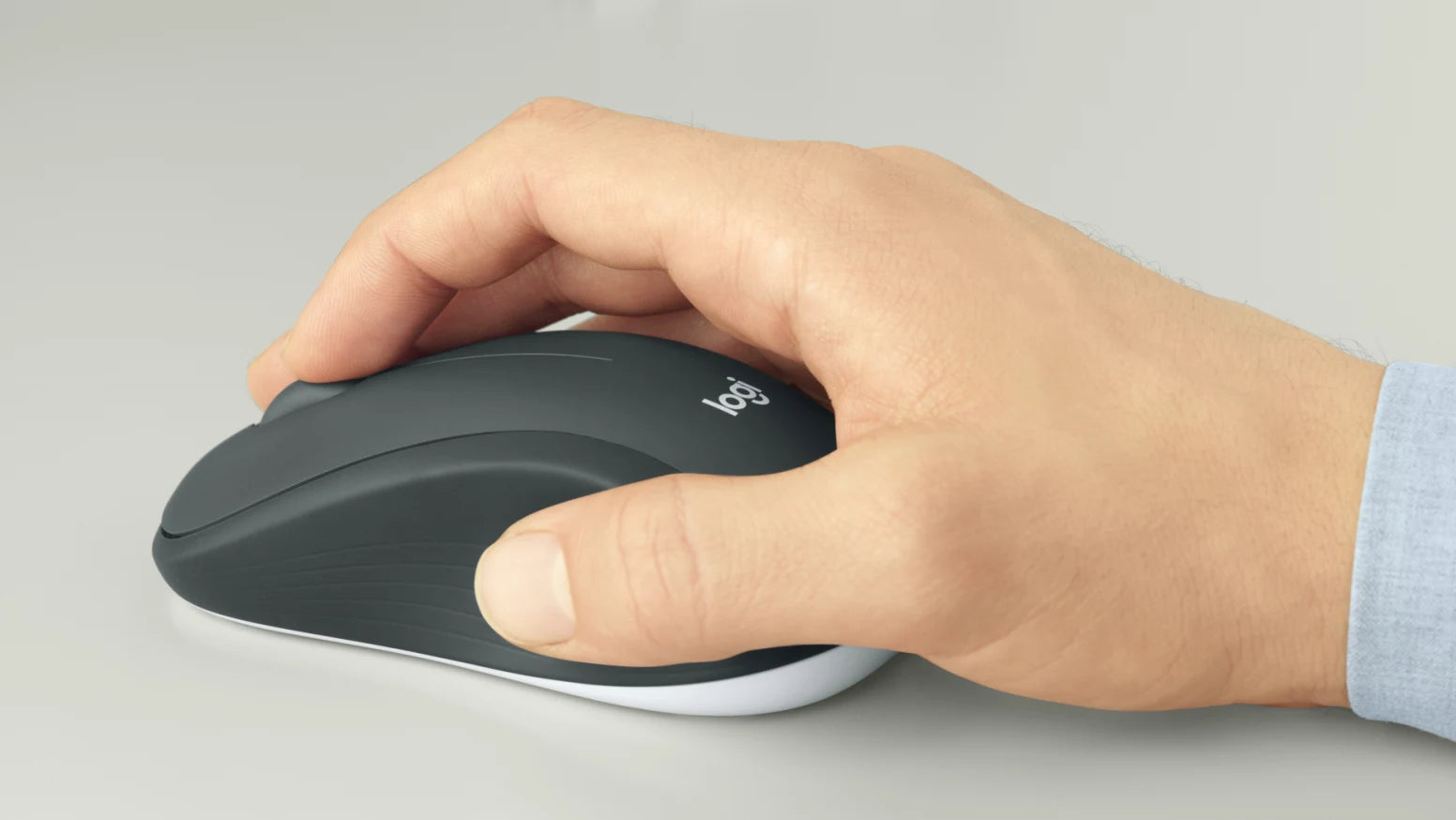 Hand bedient eine ergonomische Logitech-Computermaus auf einem hellen Schreibtisch.