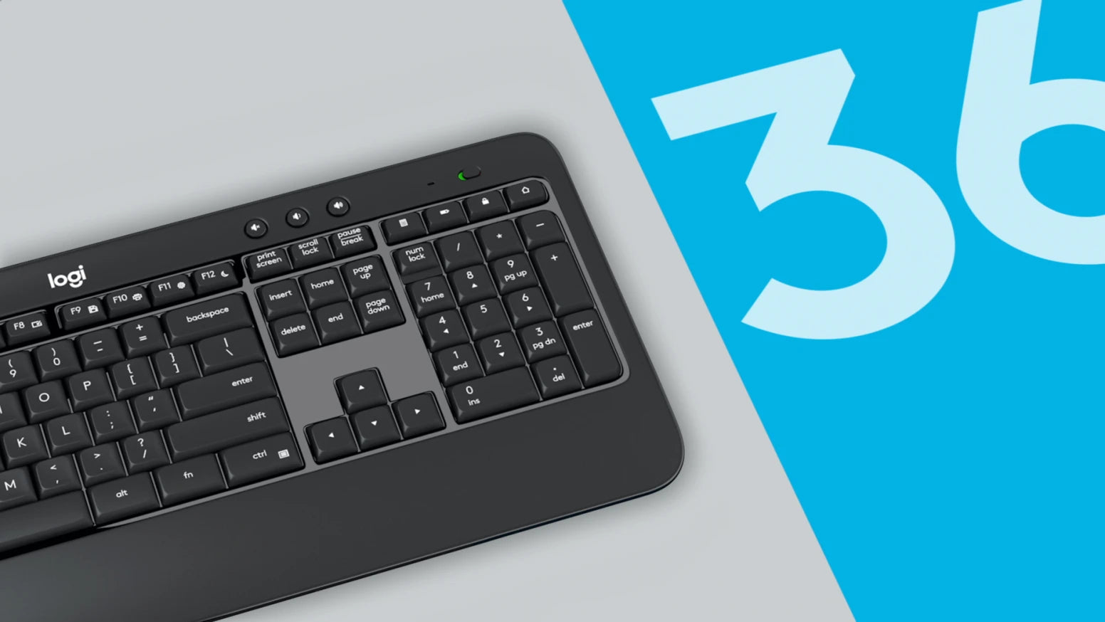 Schwarze Logitech-Tastatur mit integriertem Ziffernblock und flacher Bauweise auf grauem Tisch vor blauem Hintergrund