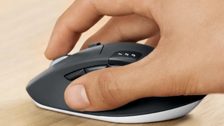 Hand bedient ergonomische High-End Computer-Maus mit Daumentasten auf einem Holztisch.